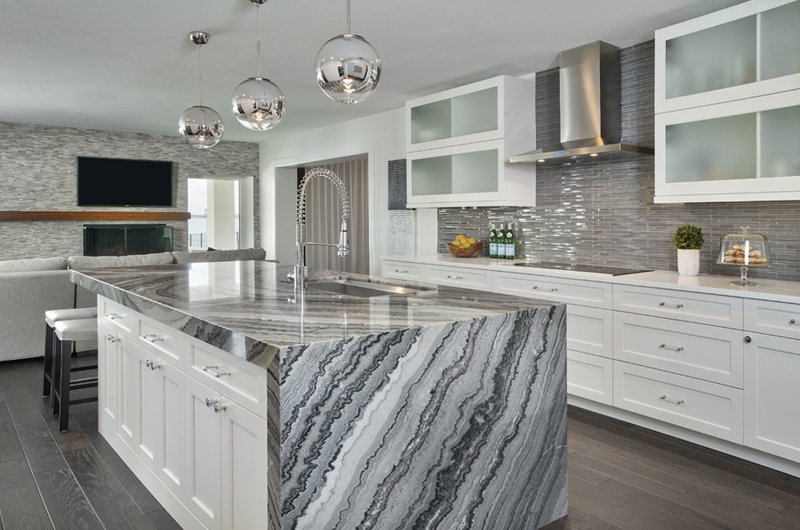 Kitchen remodel in Bonita Springs, FL with granite waterfall countertops, large island, and white shaker cabinets.